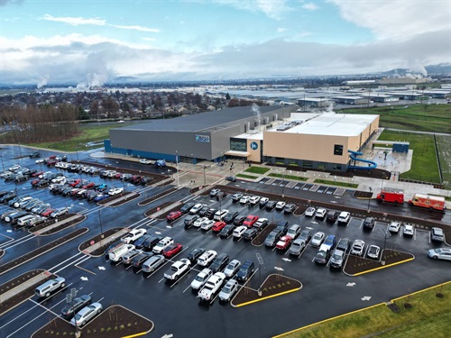 Aerial view of building with parking lot and cars